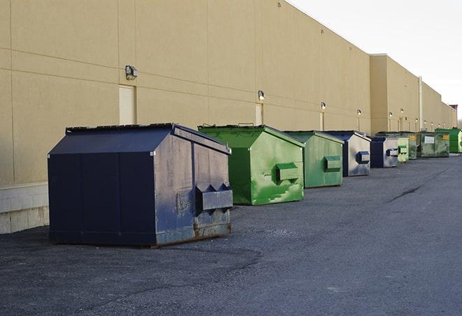 a row of yellow and blue dumpsters at a construction site in Gulfport, MS